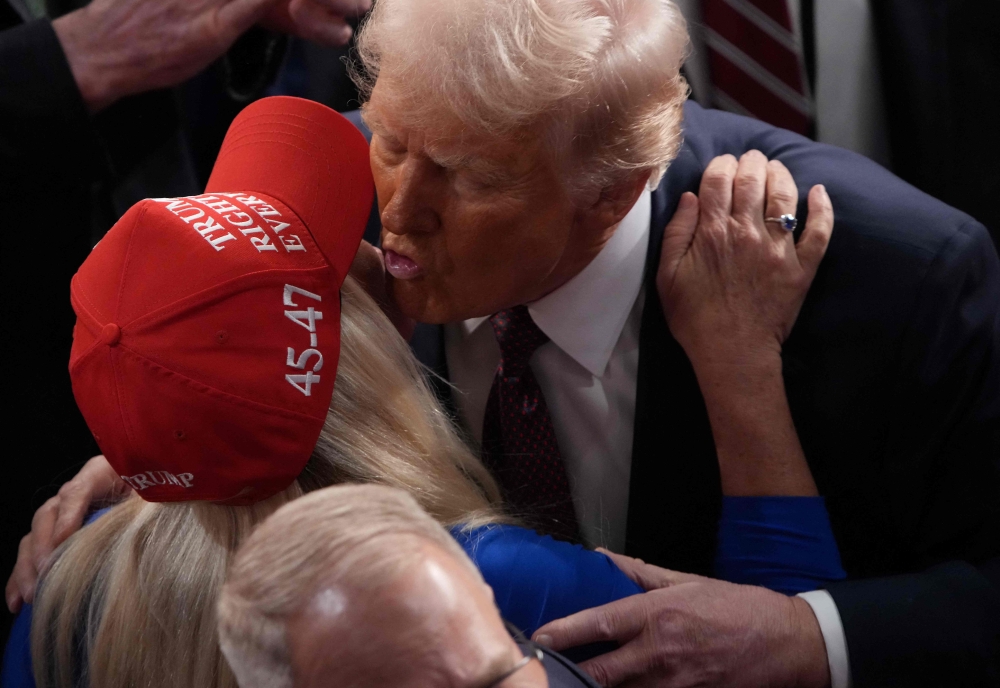 Trump kisses Republican Marjorie Taylor Greene (R-GA) after addressing a joint session of Congress at the US Capitol on March 04, 2025 in Washington, DC. — AFP pic