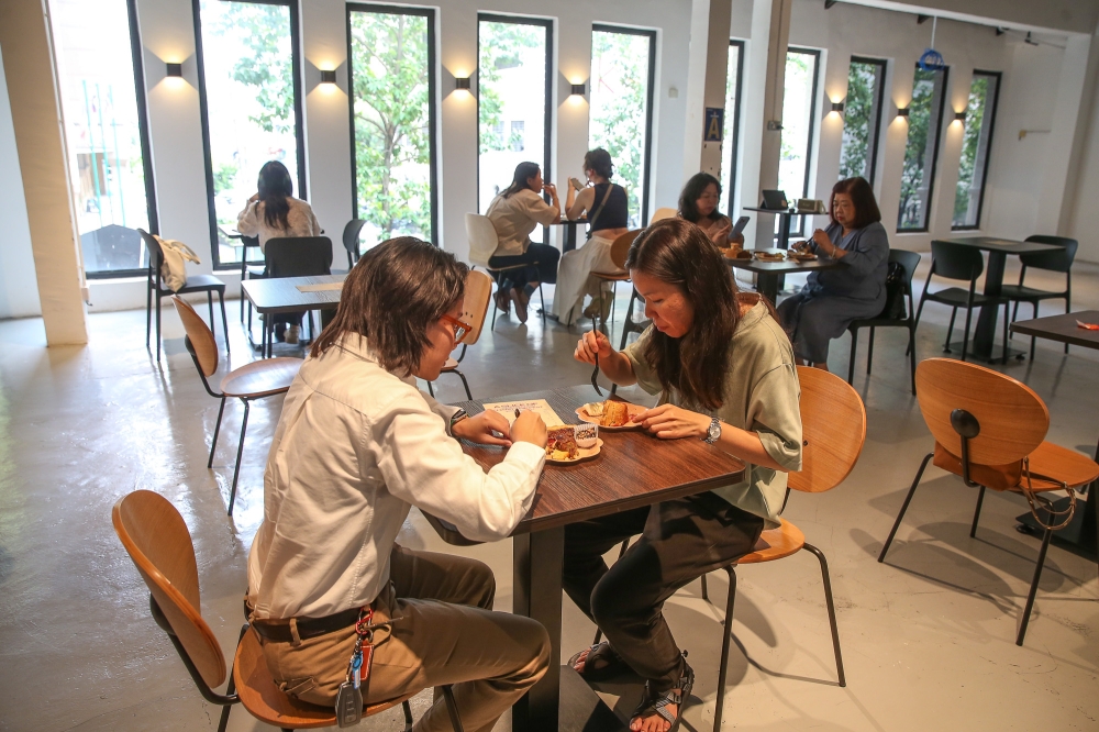 Attendees enjoying their time at the fest, savoring delicious pies. — Photo by Yusof Mat Isa 