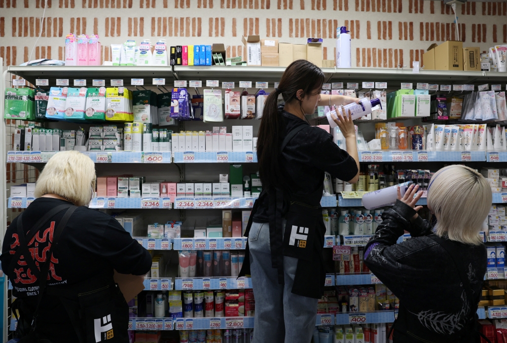 Hinako Mori and her colleagues arrange products at a store of Japanese retailer Don Quijote in Tokyo October 8, 2025. — Reuters pic