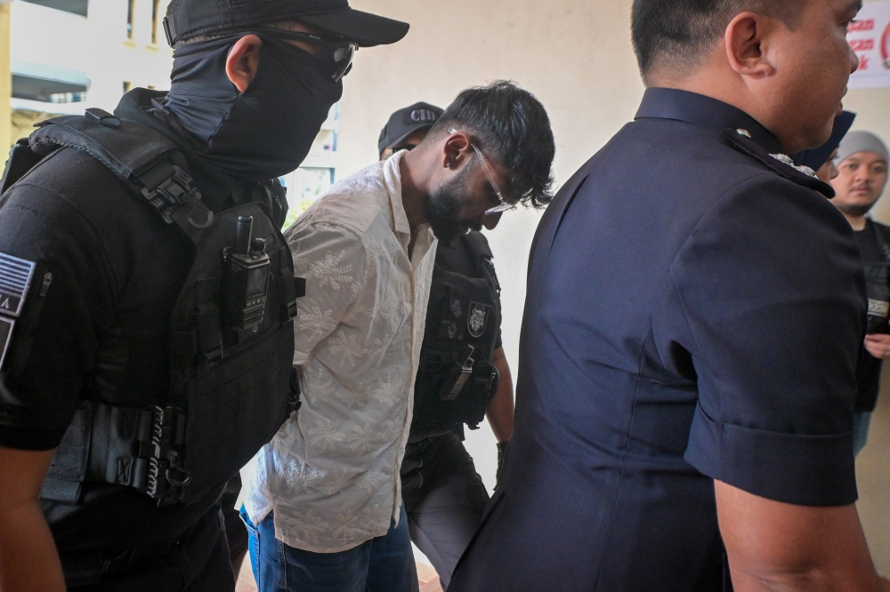 Two men appeared in the Magistrates’ Court today to be charged with murdering a saleswoman whose naked, bound body was found near the Blue Water Estate roundabout in Seri Kembangan last month. — Bernama pic 