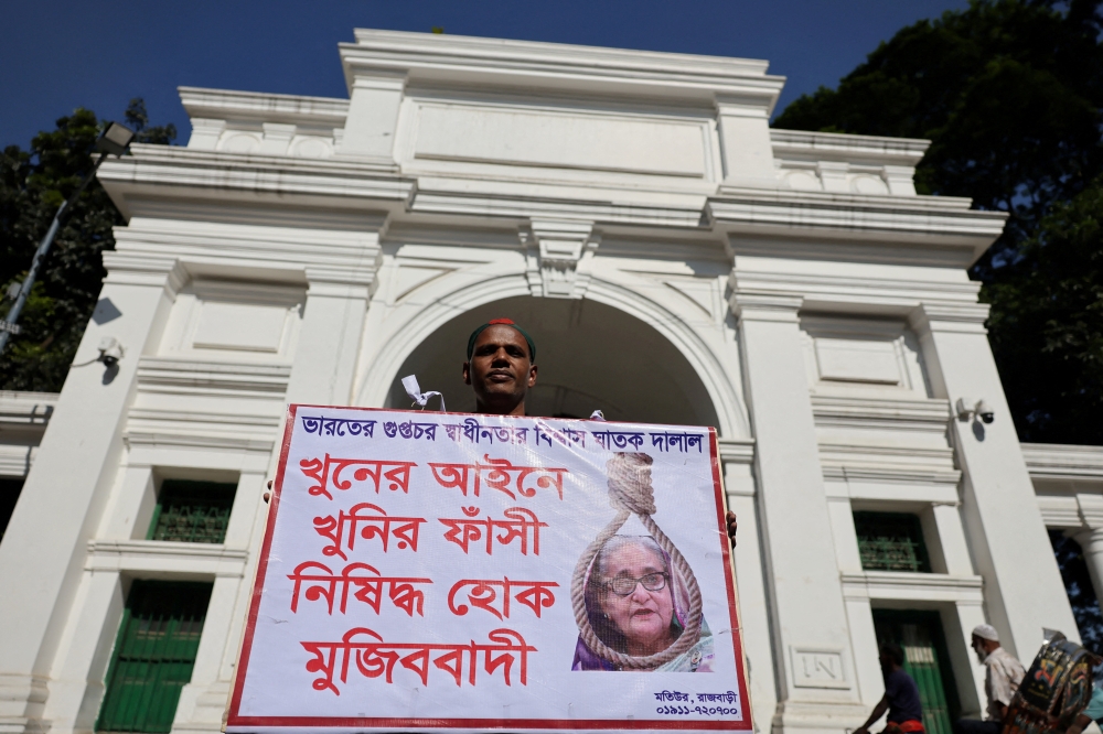 A man holds a poster demanding capital punishment against the ousted Prime Minister Sheikh Hasina, in Dhaka, Bangladesh, on November 17, 2025. — Reuters pic