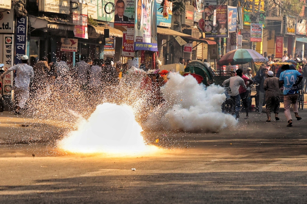 People run past a flashbang grenade police fired to disperse demonstrators, ahead of the verdict on cases against the ousted Prime Minister Sheikh Hasina, in Dhaka, Bangladesh, on November 17, 2025. — Reuters pic