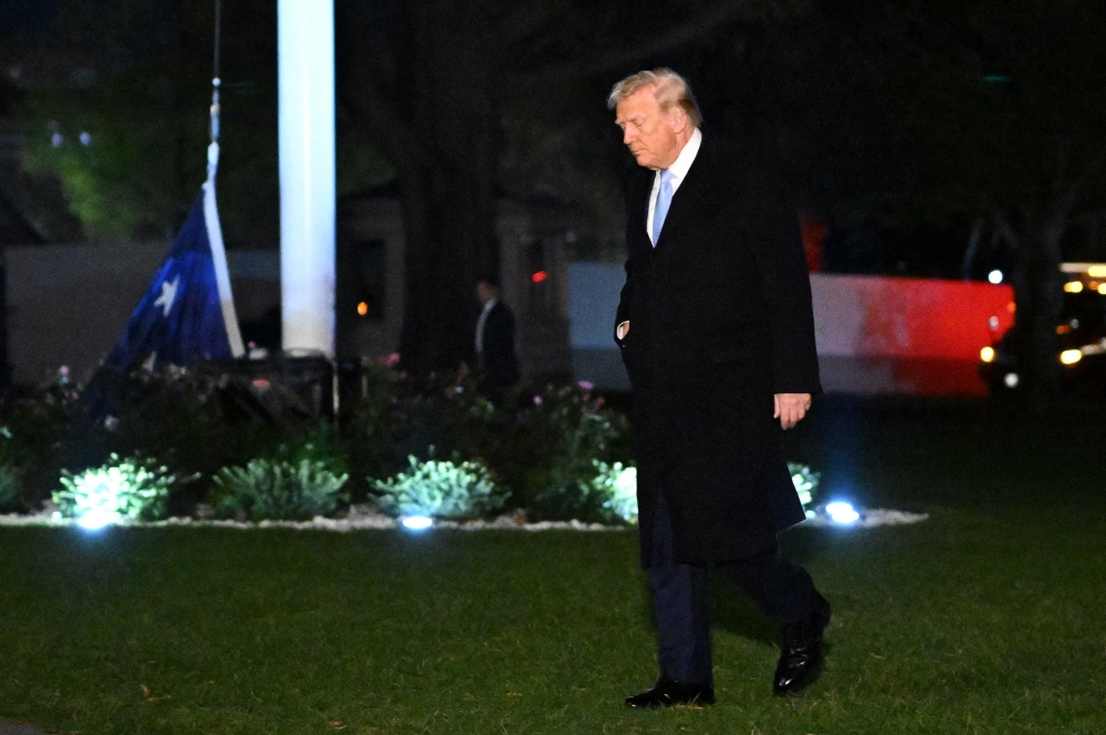 US President Donald Trump walks on the South Lawn of the White House as a US flag lies on the ground, in Washington, DC, on November 16, 2025. — AFP pic