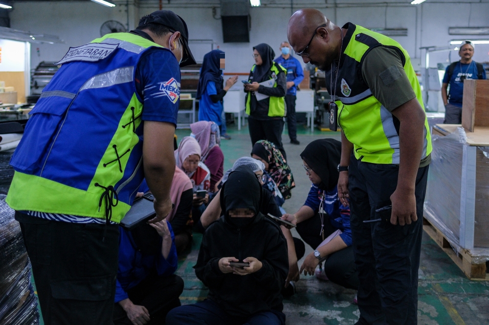 Officers from the National Registration Department (NRD) together with the Malaysian Immigration Department (JIM) conduct inspections of local and foreign workers during Ops Kotak at a box-making and printing factory in Johor Technology Park, Senai, November 17, 2025. — Bernama pic 

