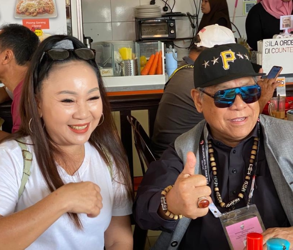 Upko president Tan Sri Pandikar Amin Mulia poses for pictures with a member of the public during a walkabout. — Picture via Facebook/PandikarAmin