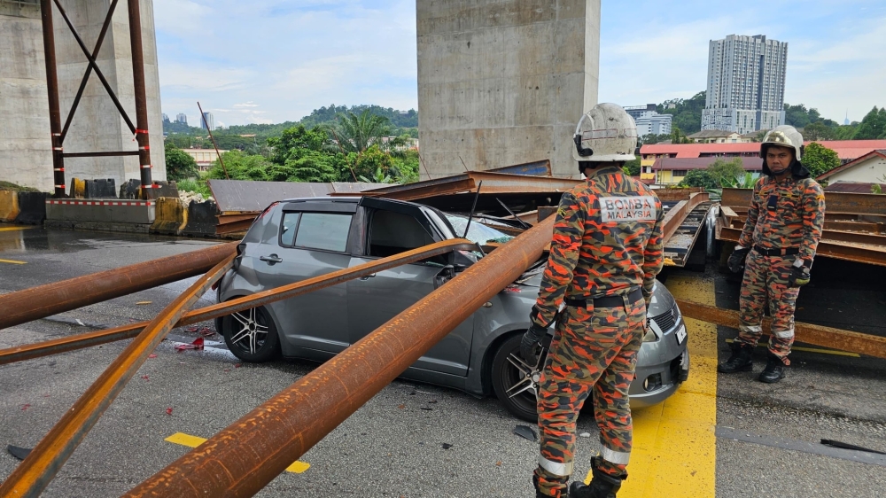 Fallen beams lay atop a Suzuki Swift along the MRR2 in Selayang, Kuala Lumpur, on Nov 18, 2025. — Bomba pic