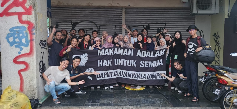Volunteers of Dapur Jalanan Kuala Lumpur (DJKL) along with student volunteers from Universiti Islam Antarabangsa Malaysia at Jalan Panggong after a weekly food serving session recently. — Picture by Arif Zikri