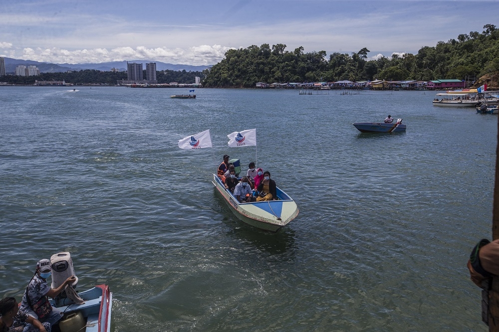File picture of voters arriving at polling station in SK Pulau Gaya by boat, September 26, 2020. — Picture by Firdaus Latif