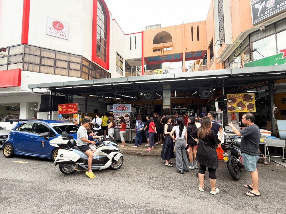Approaching lunch time, the queue swells up for those who wish to take away the food. 