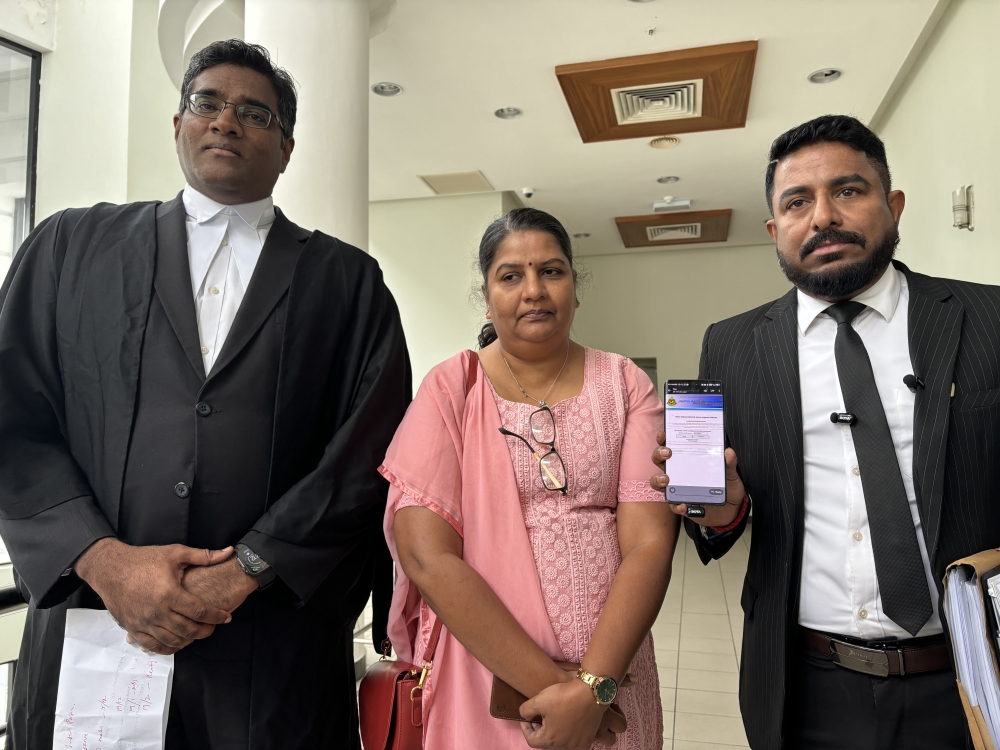 Indira Gandhi, her lawyer Rajesh Nagarajan (left), and social activist Arun Doraisamy speak to the press outside the High Court in Ipoh, Perak, on November 21, 2025. — Picture by John Bunyan
