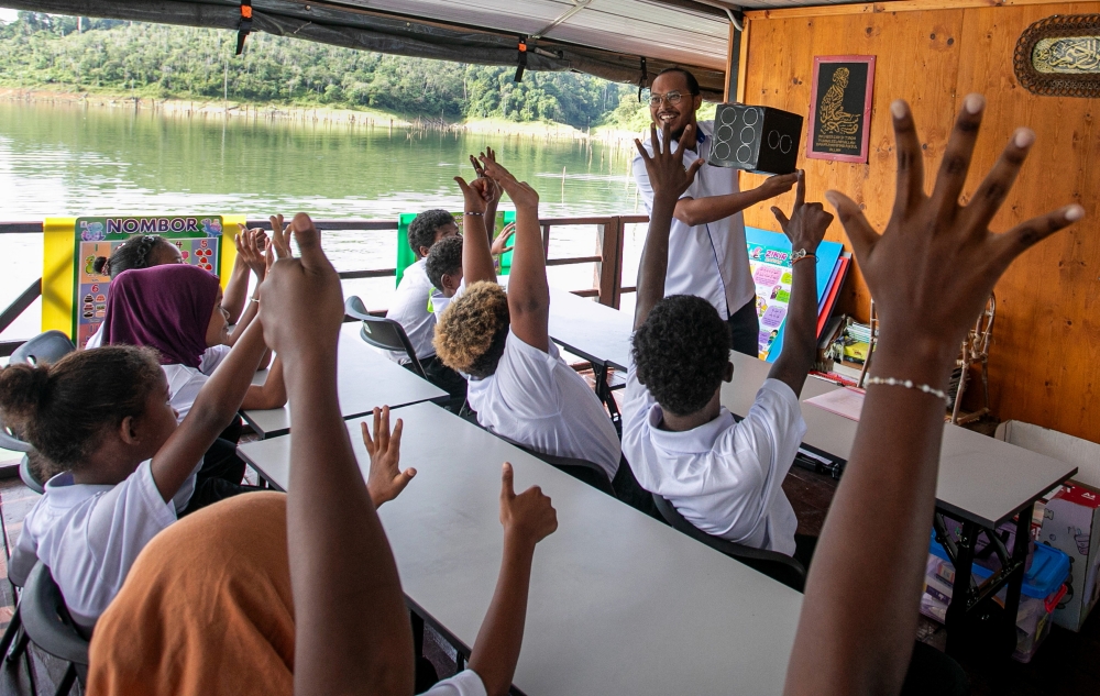 Teacher Muhammad Syauqi Zainal Abidin teaching Orang Asli pupils during the a special programme at the Lake Banding floating school in Gerik recently. — Bernama pic 