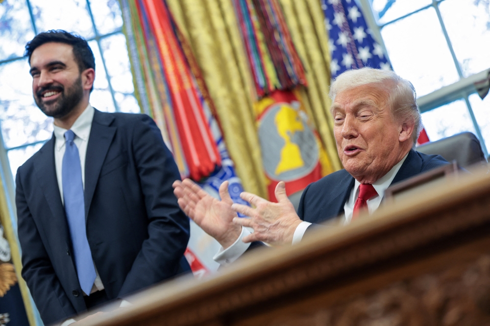 US President Donald Trump and New York City Mayor-elect Zohran Mamdani react as they speak to members of the media in the Oval Office at the White House in Washington, DC. — Reuters pic