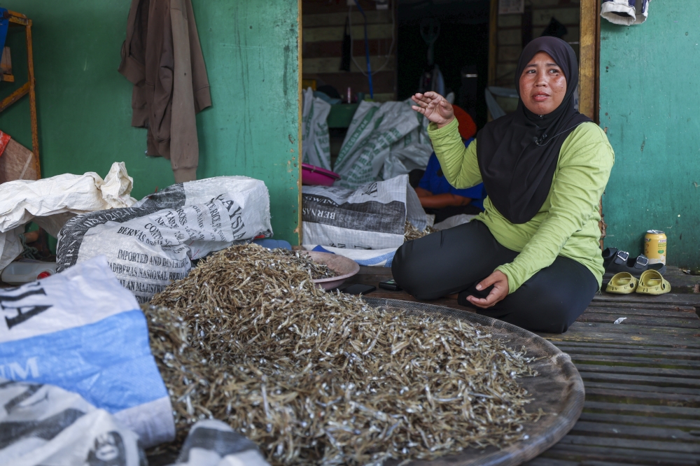 Nurmalasari Tianggi, 31, packs sun-dried anchovies for sale on November 20, 2025 at Kampung Pengkalan Laut in Kunak, Sabah. — Bernama pic