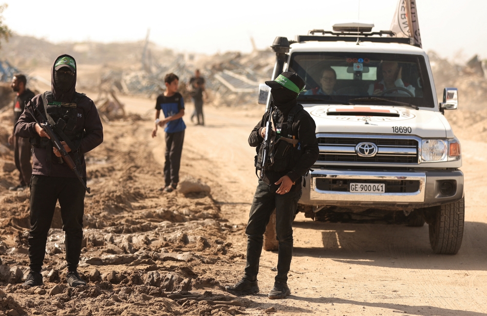 File picture of Hamas fighters escorting members of the Red Cross towards an area within the so-called ‘yellow line’ to which Israeli troops withdrew under the ceasefire, as Hamas says it continues to search for the bodies of deceased hostages seized during the October 7, 2023, attack on Israel, in Gaza City November 20, 2025. — Reuters pic 
