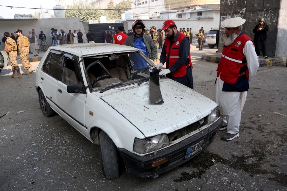 Rescue workers inspect a damaged vehicle after suicide bombers targeted the headquarters of a Pakistani paramilitary force in Peshawar, Pakistan, November 24, 2025. — Reuters pic 