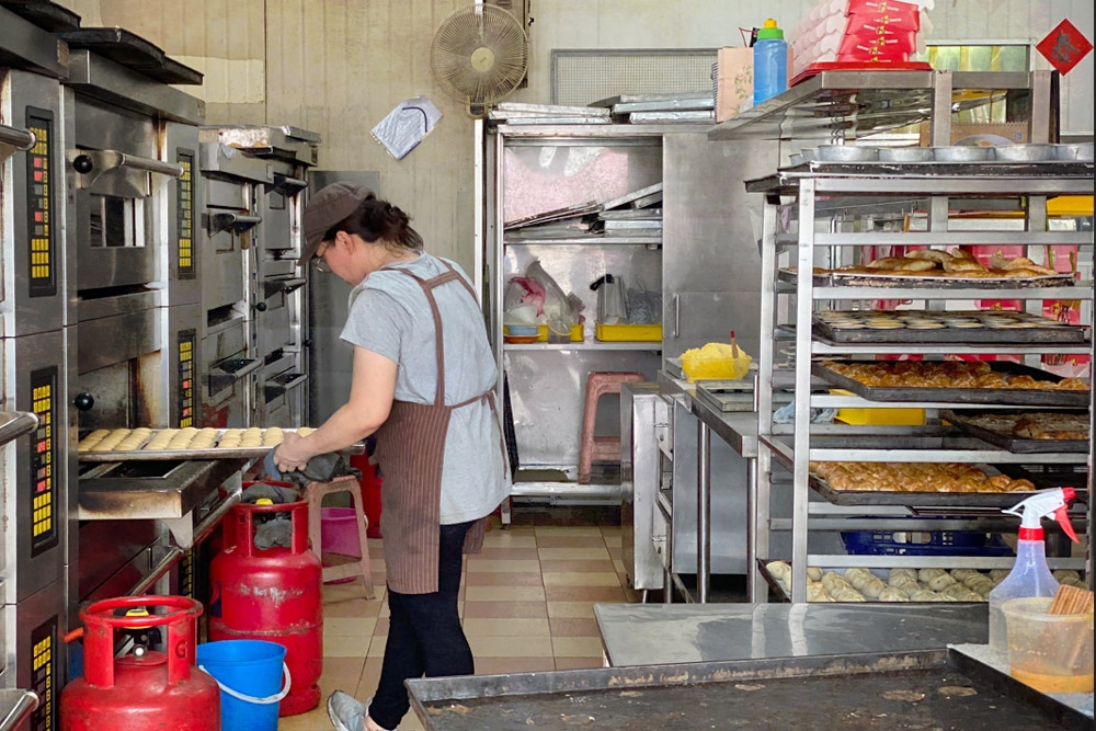 Staff arranging trays of just baked ‘siew bao’ onto cooling racks. — Picture by CK Lim