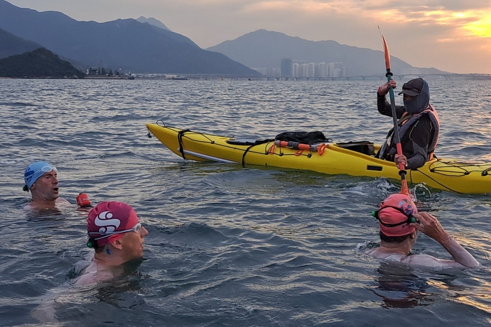 Simon Holliday, Edie Hu, and Brett Kruse are seen swimming as they circumnavigate Lantau, the largest island in Hong Kong. — Handout photo via AFP