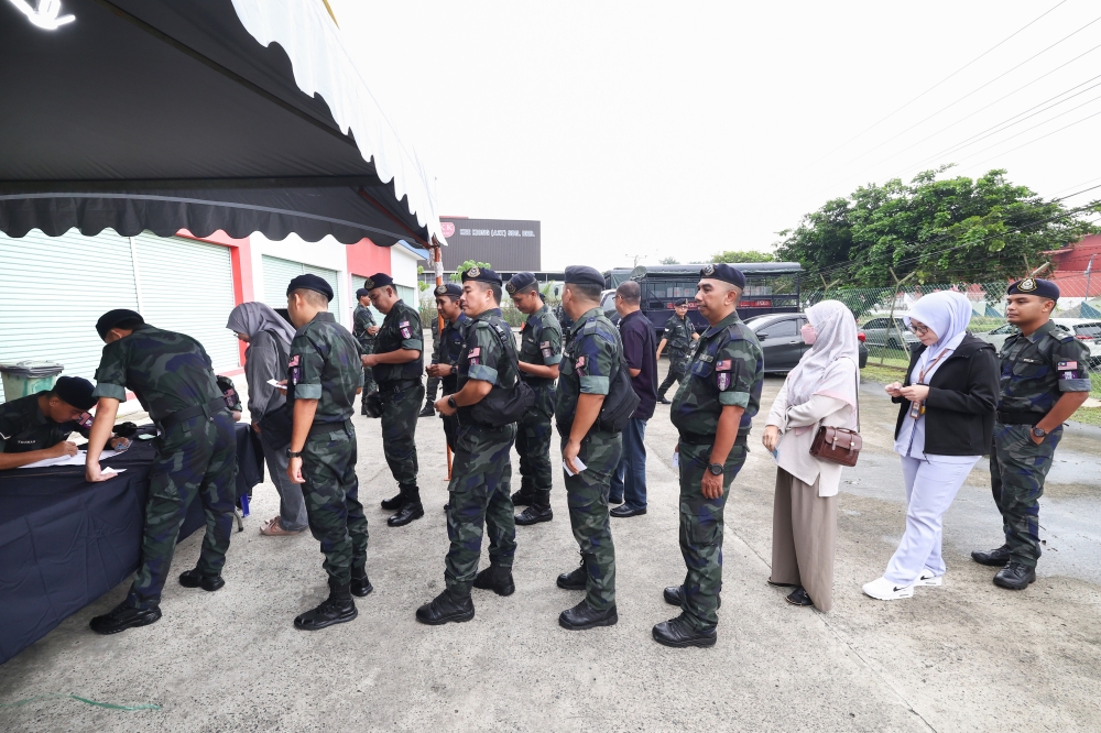 Officers check voter names and polling channels during early voting for the 17th Sabah State Election at the 15th Battalion General Operations Force multipurpose hall in Sandakan on November 25, 2025. — Bernama pic