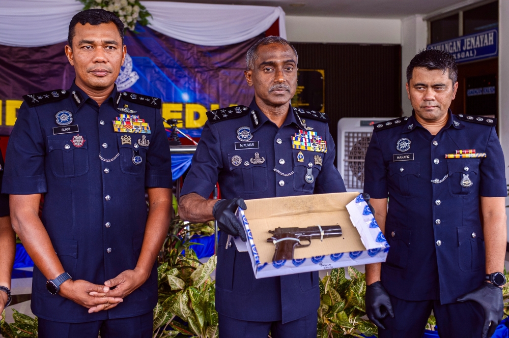Bukit Aman CID director Datuk M. Kumar (centre) displays the firearm seized following a police shootout with a wanted armed robber in Dengkil, Selangor on November 25, 2025. — Bernama pic