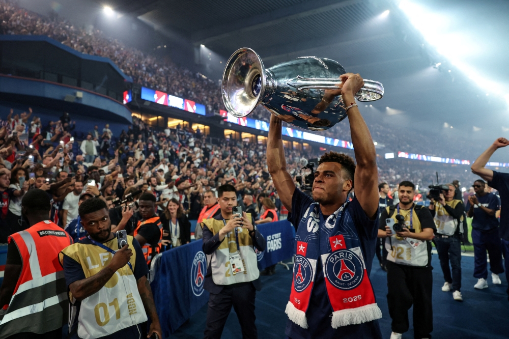 Paris St Germain’s Desire Doue celebrates with supporters in Paris after the club won the Uefa Champions League earlier this year. The club’s Champions League win has coincided with a strategic shift toward academy talent, backed by a €350 million training campus. — Reuters pic