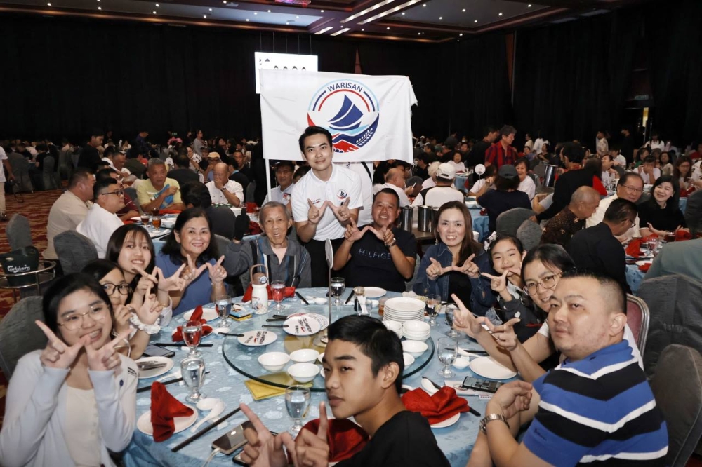 Warisan’s Kota Kinabalu candidate Loi Kok Liang (centre, in white polo shirt) poses with supporters during a dinner event while campaign. — Picture from Facebook/Liang - Loi Kok Liang