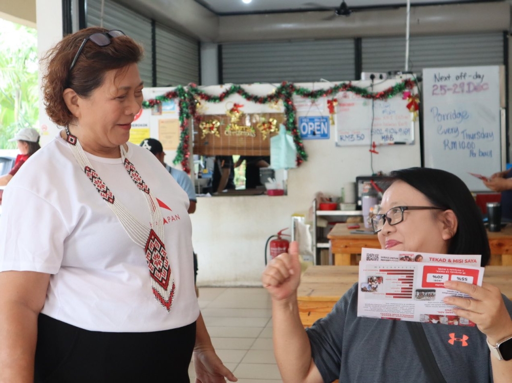 Pakatan Harapan’s Datuk Jannie Lasimbang (left) who is defending Kepayan in the Sabah election interacts with a voter during her campaign walkabout. — Picture from Facebook/Jannie Lasimbang