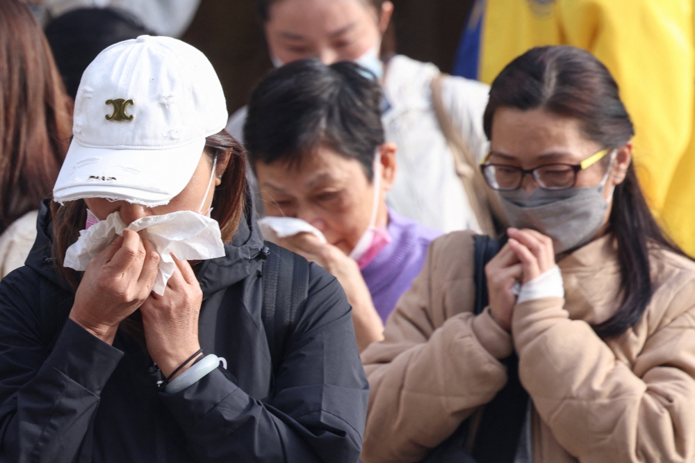 Relatives react after identifying family members from photos at Kwong Fuk Community Hall following the Wang Fuk Court housing estate fire, in Tai Po, Hong Kong, China, November 27, 2025. — Reuters pic  