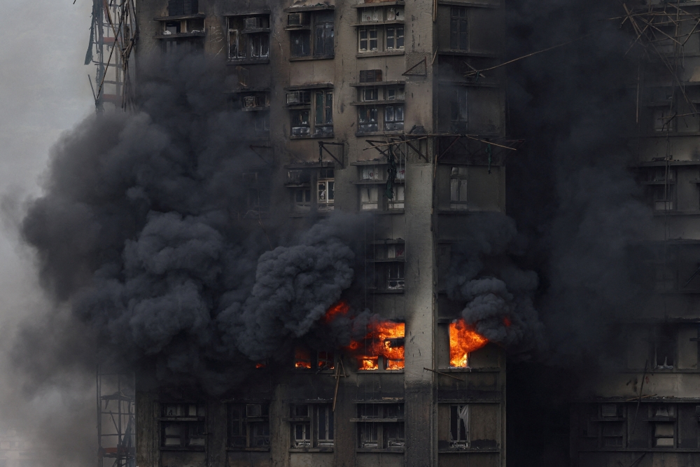 Thick smoke billows from the upper floors of a residential block at Wang Fuk Court housing estate during a major fire that engulfed bamboo scaffolding across multiple buildings, in Tai Po, Hong Kong November 27, 2025. — Reuters pic  