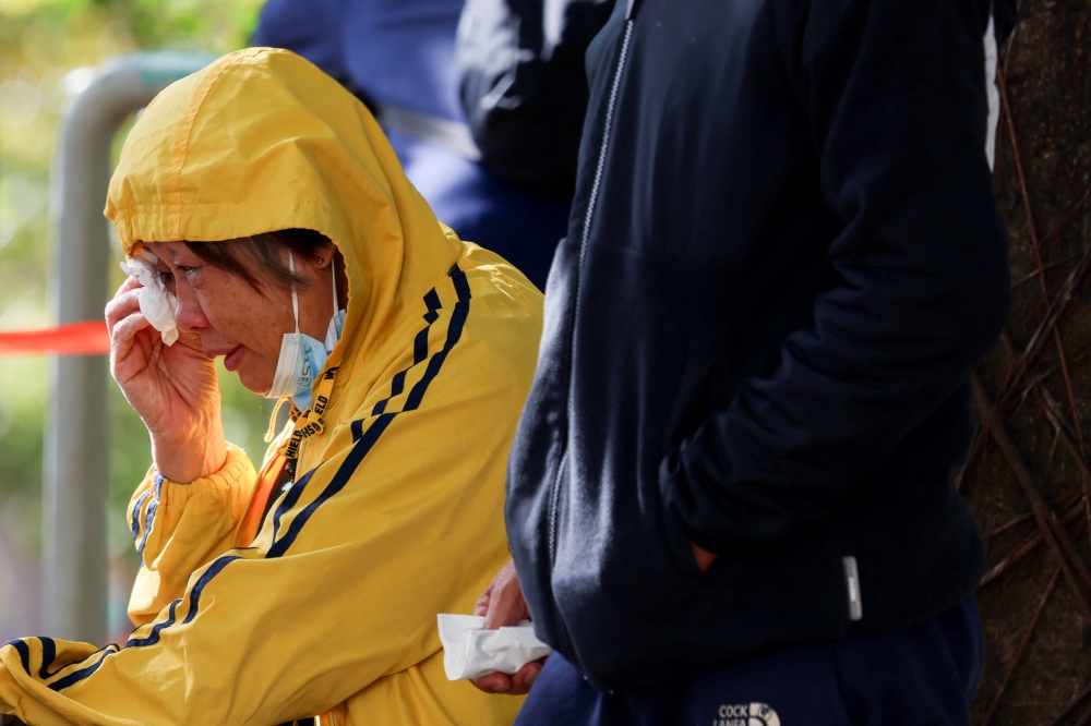 A woman reacts outside the Kwong Fuk Community Hall, where relatives identify family members from photos, following the Wang Fuk Court housing complex fire, in Tai Po, Hong Kong, China, on November 28, 2025. — Reuters pic