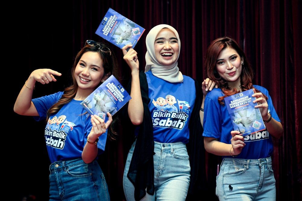 Supporters display the Barisan Nasional manifesto at the launch of the “Sabah Development Plan 1” Manifesto for the 17th Sabah State Election at the UMNO Building in Kota Kinabalu on November 22, 2025. — Bernama pic