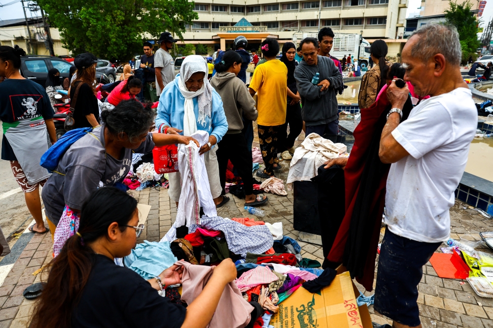 People search through donated clothes in a flooded area in Hat Yai district, Songkhla province, Thailand, on November 28, 2025. — Reuters pic
