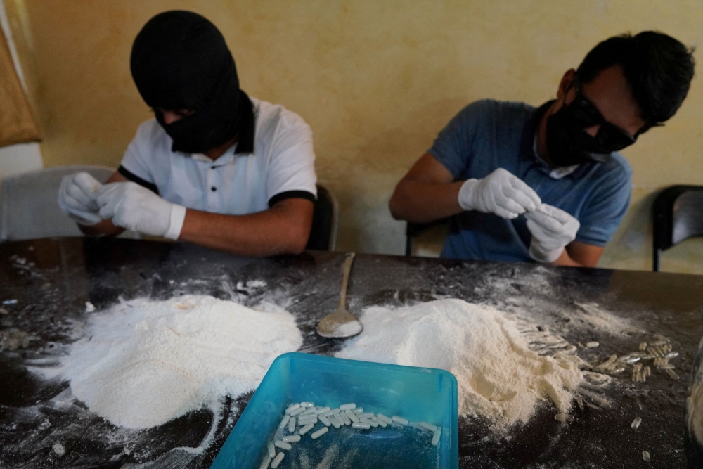 File picture of members of the Sinaloa Cartel preparing capsules with methamphetamine in a safe house in Culiacan, Mexico, April 4, 2022. — Reuters pic