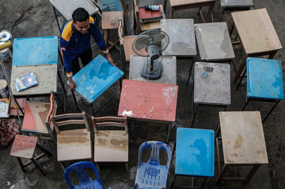 Nearly 100 volunteers, comprising university students, lecturers and staff from Universiti Malaysia Perlis (UniMAP), rolled up their sleeves to clean up the grounds of Sekolah Menengah Dato Sheikh Ahmad as soon as the floodwaters began to recede today. — Bernama pic