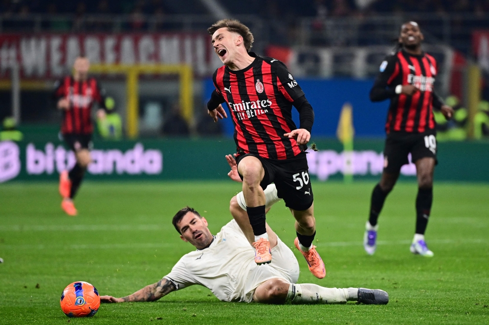 AC Milan's Begian midfielder #56 Alexis Saelemaekers (centre) fights for the ball with Lazio's Italian defender #13 Alessio Romagnoli (down) during the Italian Serie A football match between AC Milan and Lazio at the San Siro stadium in Milan on November 29, 2025. — AFP pic