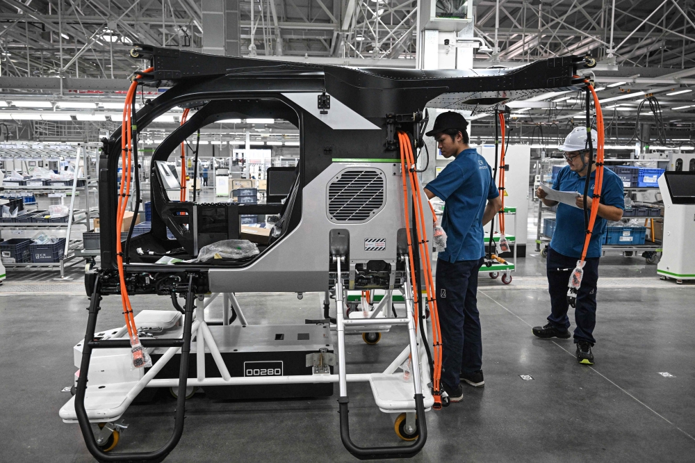 Employees work on the assembly line for the electric flying car Land Aircraft Carrier at a factory in Guangzhou November 6, 2025. — AFP pic