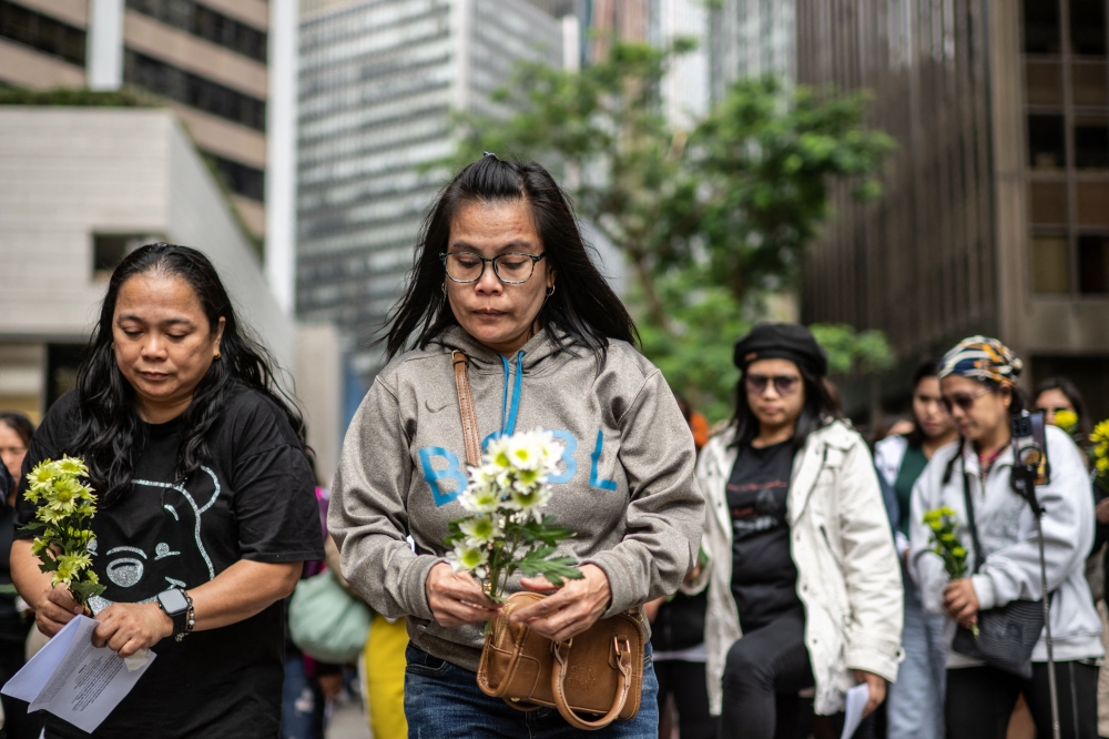 Philippine nationals in Hong Kong take part in a community prayer service for victims of the deadly November 26 fire at Tai Po. — AFP pic