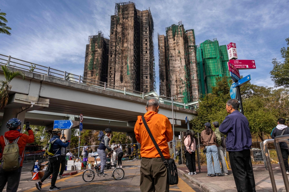 People look at the aftermath of a major fire that swept through several apartment blocks at the Wang Fuk Court residential estate in Hong Kong. — AFP pic