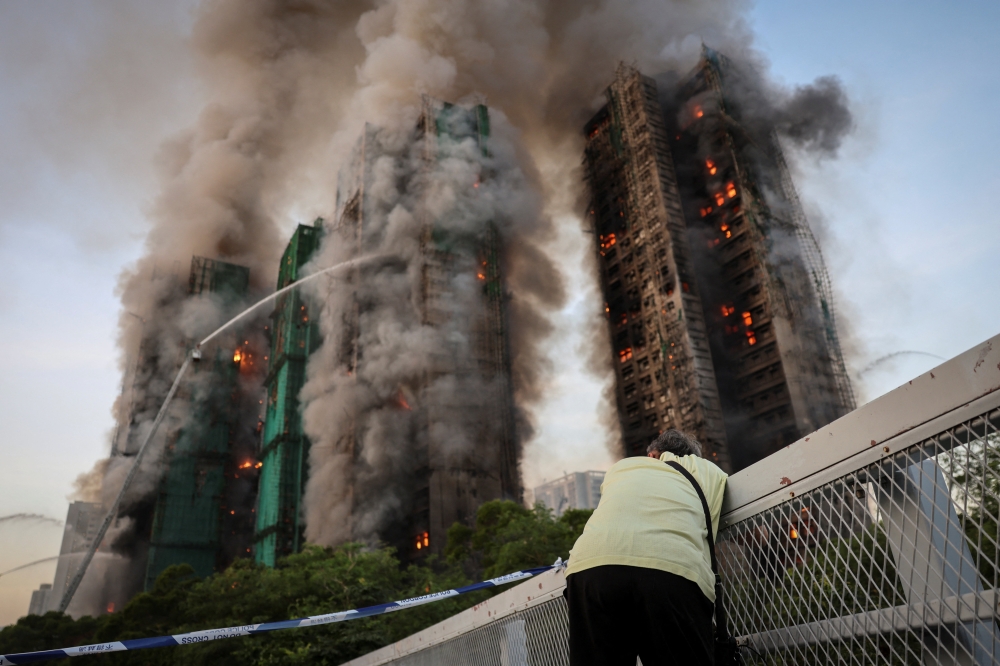 Wong, 71, reacts after saying his wife is trapped inside Wang Fuk Court during a major fire, in Tai Po, Hong Kong November 26, 2025. — Reuters pic