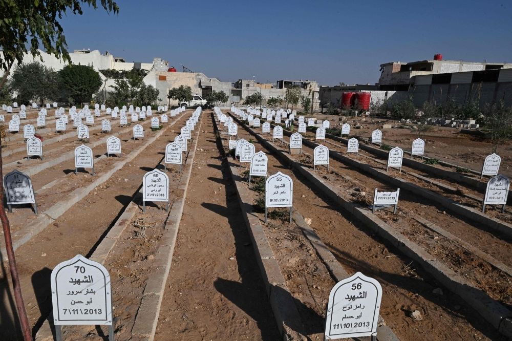The grave stones cast a shadow in the ‘Cemetery of Martyrs’ in Daraya. — AFP pic 