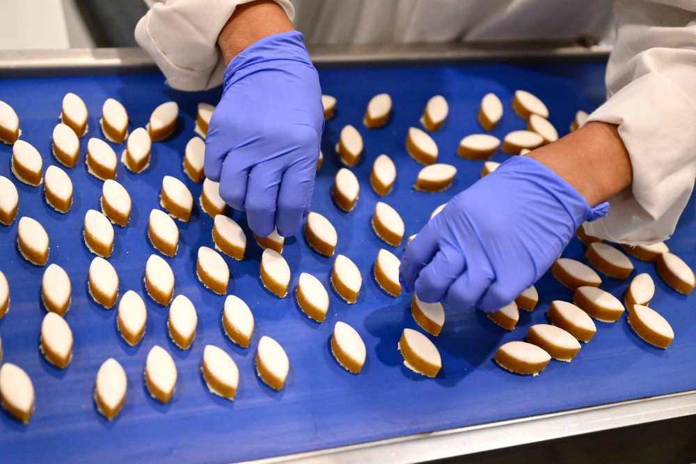 An employee works at the Le Roy Rene factory producing traditional pastries called calissons made with almonds in Aix-en-Provence, southern France, on November 18, 2025. — AFP pic