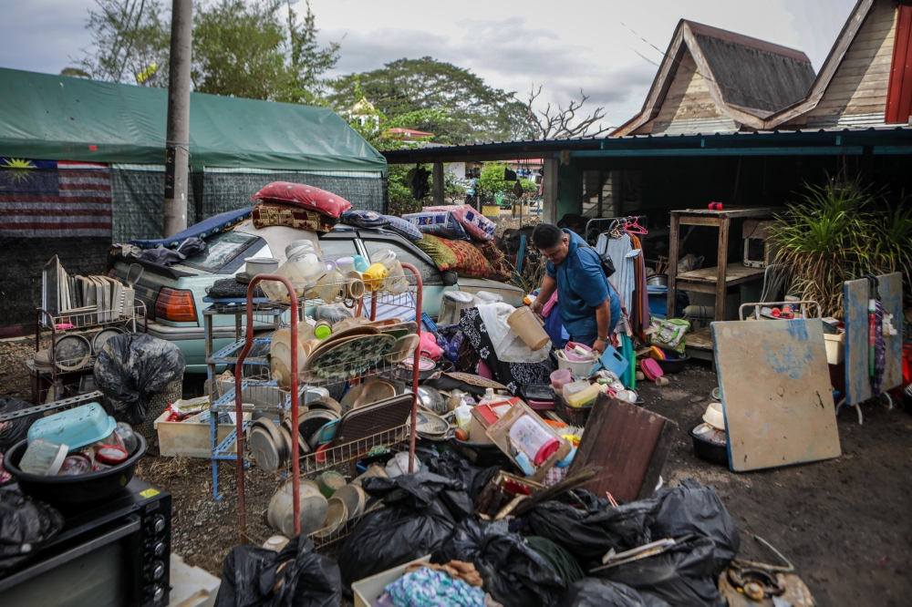 Residents of Kampung Tasoh clean their homes diligently after floodwaters recede in Padang Besar yesterday. — Bernama pic
