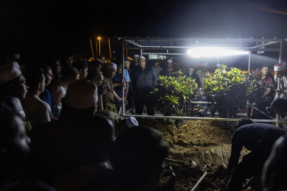 The burial of teacher Hassan Shazali, 52, who died after a vehicle plunged 60 metres into a ravine at Km 52 of Jalan Kuala Jeneris–Sungai Gawi–Aring (Bukit Kawah) near Tasik Kenyir yesterday, is seen at the Kedai Menanti Islamic Cemetery in Pasir Puteh December 6, 2025. — Bernama pic