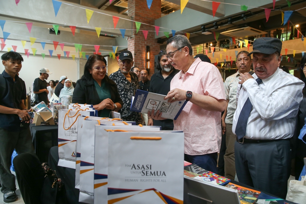 Chief Justice Datuk Seri Wan Ahmad Farid Wan Salleh (second right) checks out an exhibition booth at the 4th Human Rights Festival, held at The Ground, MAHSA Avenue in Petaling Jaya, Selangor on December 7, 2025. — Picture by Yusof Isa