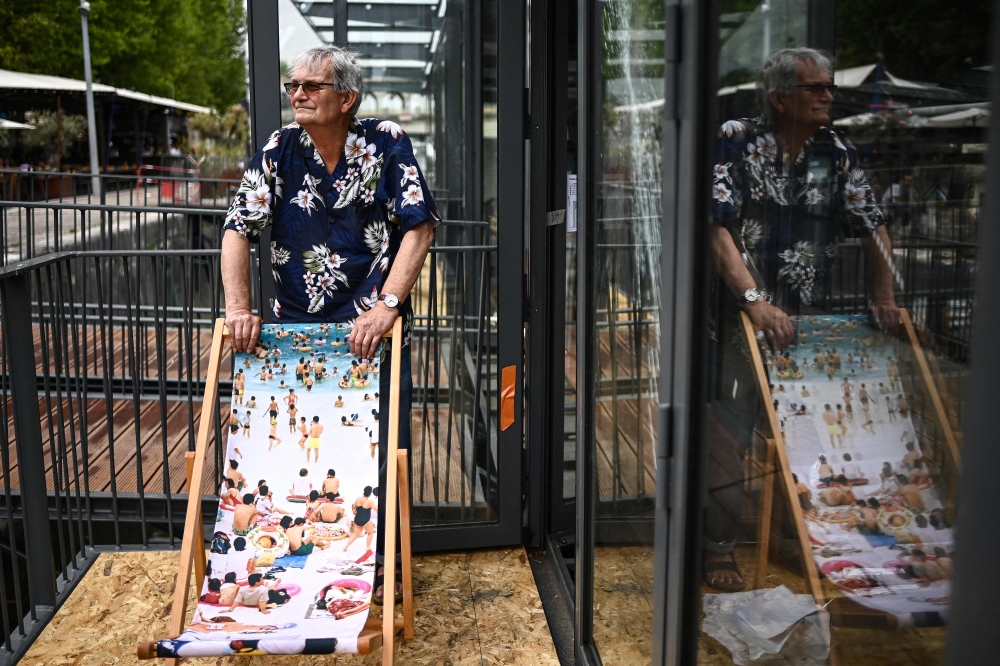 British photographer Martin Parr poses with a deckchair carrying one of his “Life’s a beach” photographs in Paris on June 19, 2023. — AFP pic