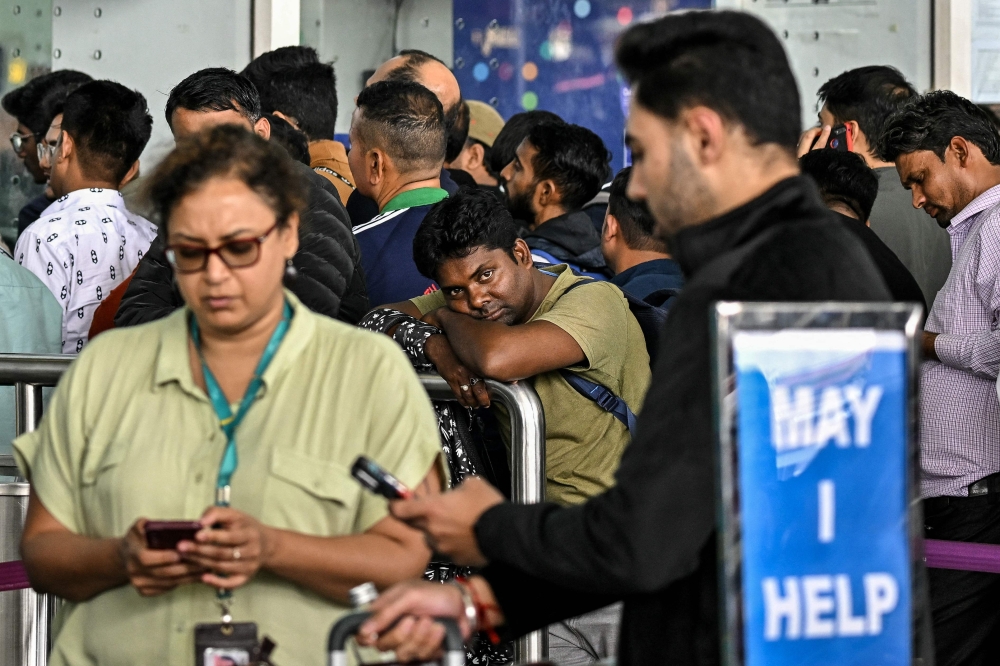 Passengers wait outside the IndiGo Airlines kiosk at the Kempegowda International Airport in Bengaluru on December 6, 2025. — AFP pic