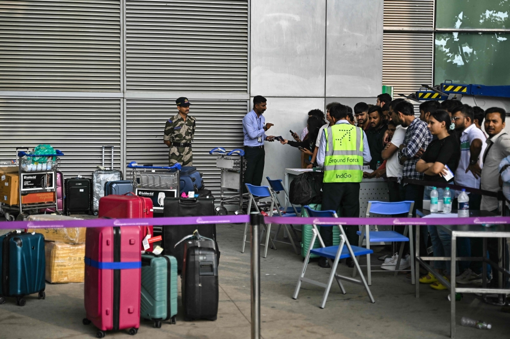 Stranded passengers wait to collect their luggage at the baggage collection area of Kempegowda International Airport in Bengaluru December 6, 2025. — AFP pic