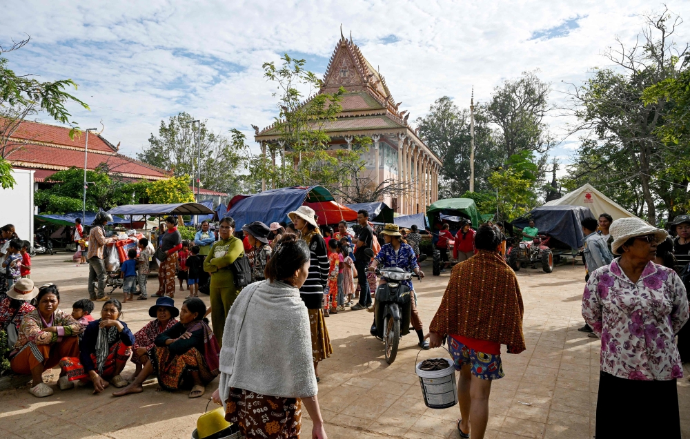 Displaced residents walk at a temporary camp set up at a pagoda during clashes along the Cambodia-Thailand border in Cambodia's Siem Reap province on December 11, 2025. — AFP pic