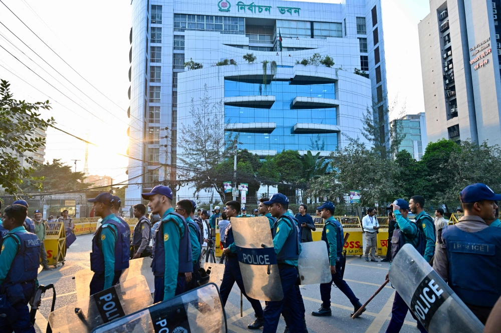 Bangladesh police personnel stand guard outside the Election Commission’s office in Dhaka on December 11, 2025, ahead of the announcement of the parliamentary elections and the July National Charter referendum. — AFP pic