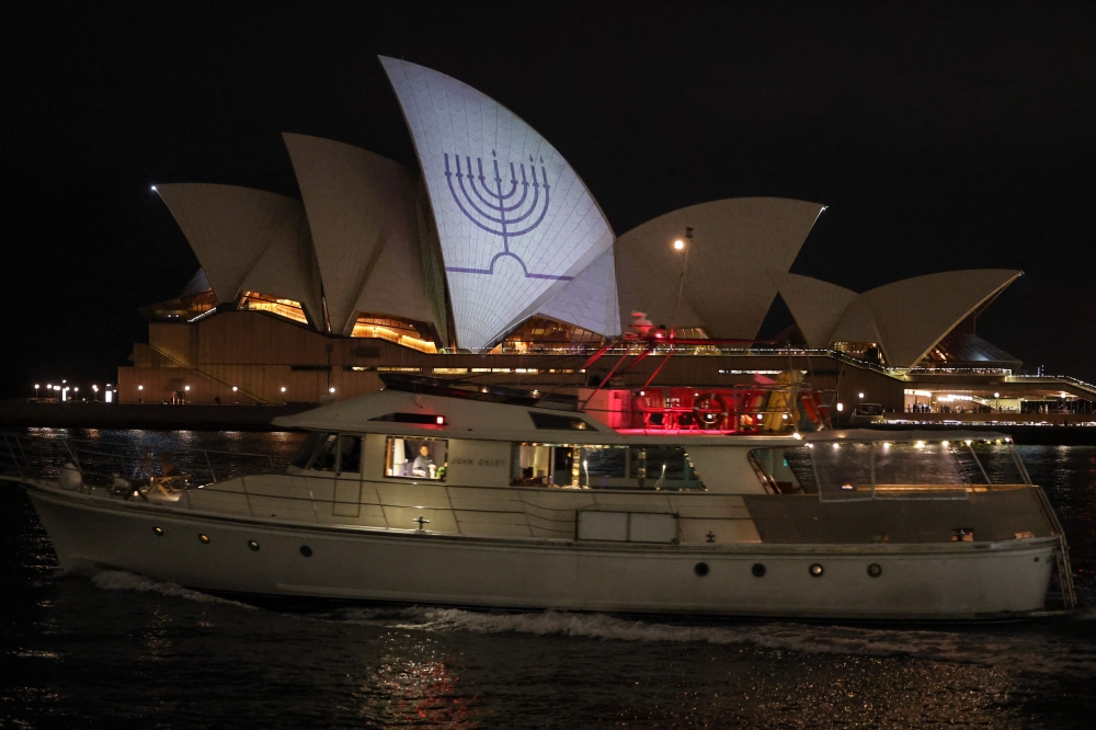 A Hanukkah menorah is projected onto the sails of the Sydney Opera House in memory of the victims of a shooting at Bondi Beach, in Sydney December 15, 2025. — AFP pic 