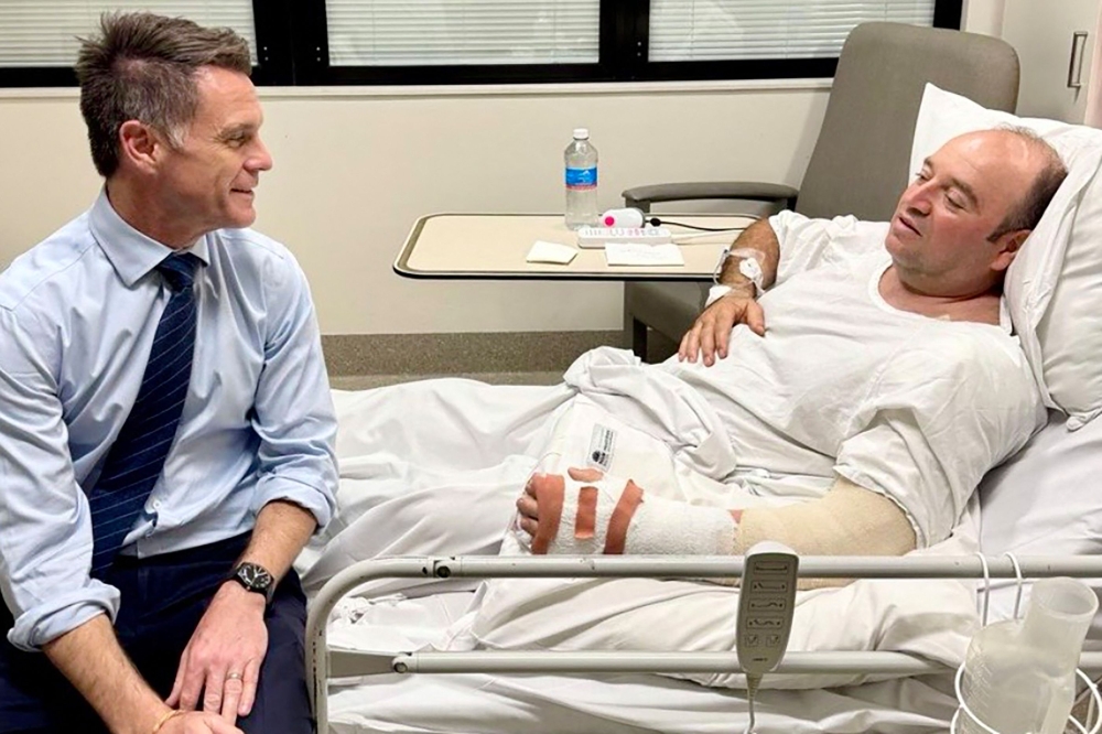 This handout photo taken and received from the NSW Premier's Department on December 15, 2025 shows New South Wales Premier Chris Minns (left) talking with Ahmed Al Ahmed, the man who tackled and disarmed one of the Bondi beach attackers, at St George Hospital in Sydney. — NSW Premier's Department handout/AFP pic 